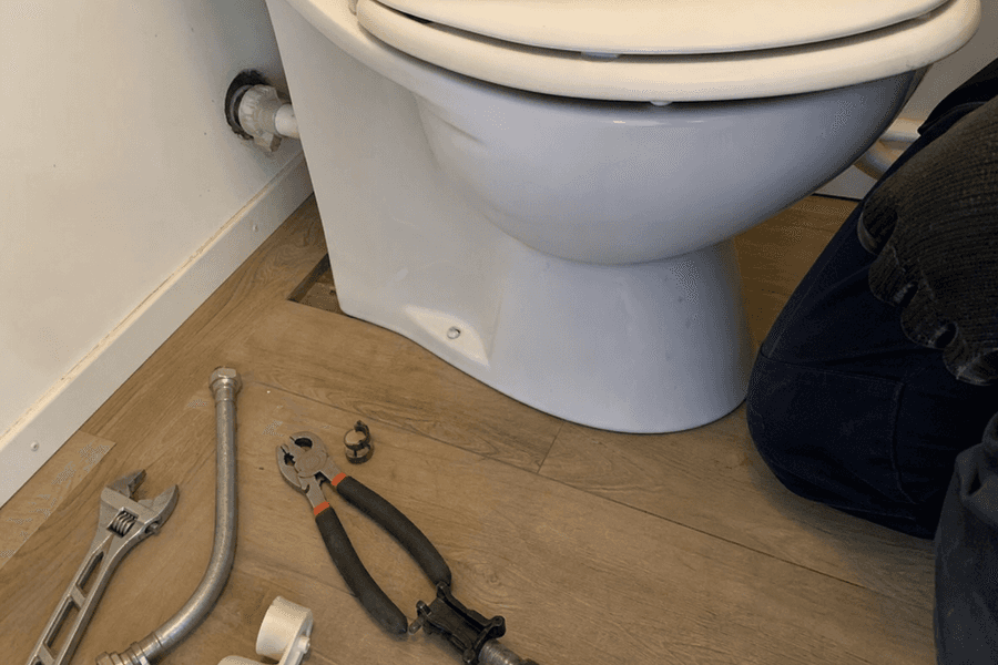 outillage de plombier posé près d'une cuvette de WC