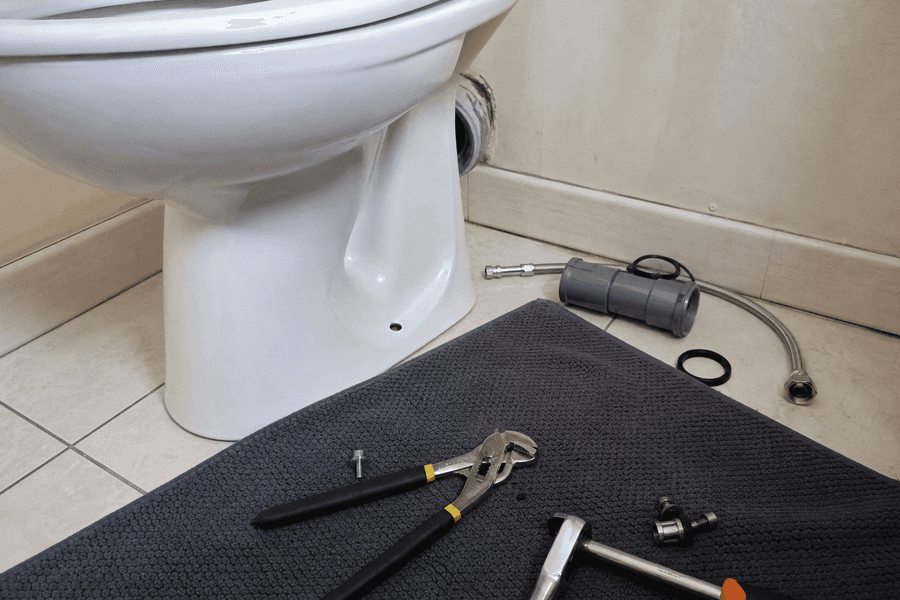 outillage de plombier posé près d'une cuvette de WC