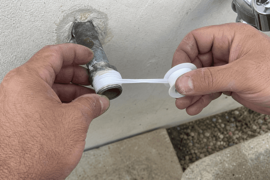 plombier appliquant ruban étanchéité sur raccord lavabo